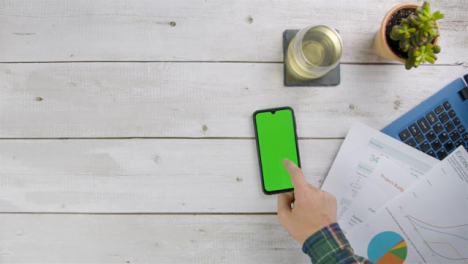 Man-Scrolling-On-His-Smart-Phone-with-Green-Screen